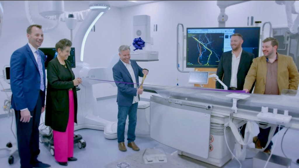 Dr. Nutting cutting a ribbon in his new office