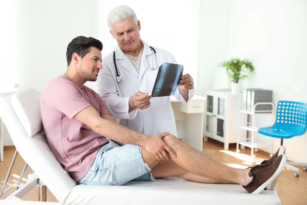Doctor reviewing a knee image with a patient during a consultation